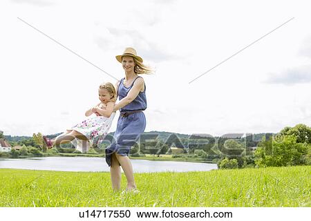Mother lifting daughter in field View Large Photo Image Stock Image - Mother lifting daughter in field. Fotosearch