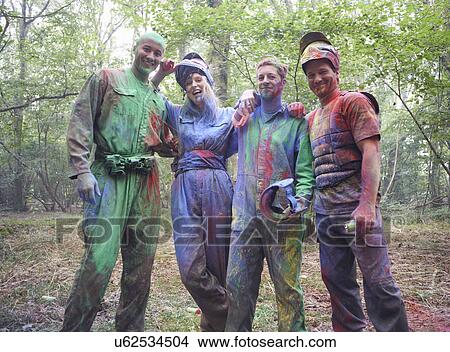 Picture - Paintball players in paintball wear marked with paint. Fotosearch