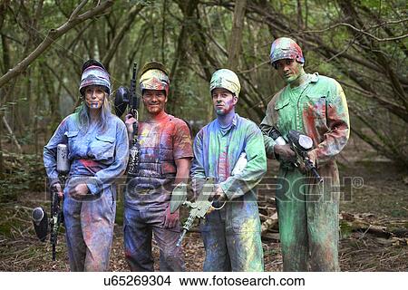 Picture - Paintball players in paintball wear marked with paint. Fotosearch