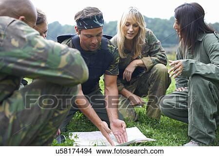 Picture - Paintball players preparing and planning game. Fotosearch