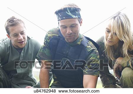Stock Photo - Paintball players preparing and planning game. Fotosearch