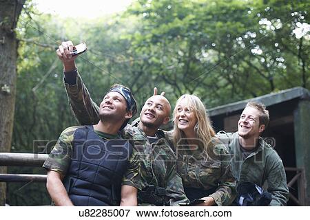 Stock Photo - Paintball players taking a picture of themselves. Fotosearch