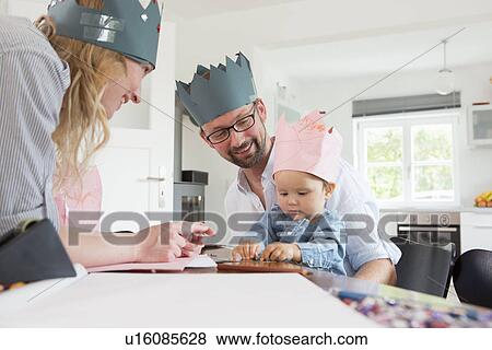 Parents with baby daughter wearing homemade crowns View Large Photo Image Stock Photo - Parents with baby daughter wearing homemade crowns. Fotosearch