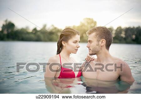 Picture - Passionate young couple standing face to face in lake. Fotosearch