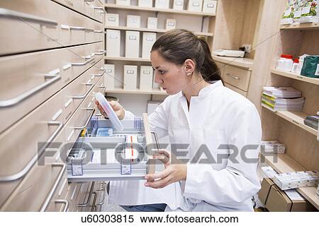 Pharmacist in pharmacy opening medicine file drawer View Large Photo Image Stock Photography - Pharmacist in pharmacy opening medicine file drawer. Fotosearch
