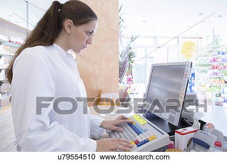 Pharmacist in pharmacy using computer View Large Photo Image Stock Image - Pharmacist in pharmacy using computer. Fotosearch