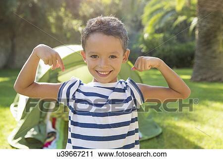 Portrait of boy in garden flexing muscles View Large Photo Image Stock Image - Portrait of boy in garden flexing muscles. Fotosearch
