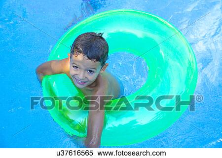Portrait of boy in inflatable ring in garden swimming pool View Large Photo Image Stock Photography - Portrait of boy in inflatable ring in garden swimming pool. Fotosearch