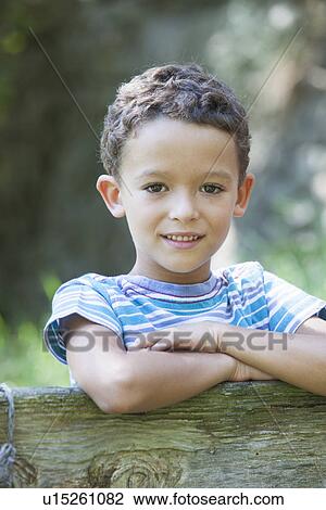 Portrait of boy leaning on garden fence View Large Photo Image Stock Image - Portrait of boy leaning on garden fence. Fotosearch