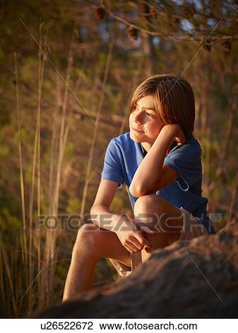 Portrait of boy sitting gazing from rock, Majorca, Spain View Large Photo Image Stock Image - Portrait of boy sitting gazing from rock, Majorca, Spain. Fotosearch