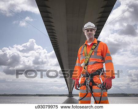 Stock Photography - Portrait of bridge worker under suspension bridge. The Humber Bridge, UK was built in 1981 and at the time was the world's largest single-span suspension bridge. Fotosearch