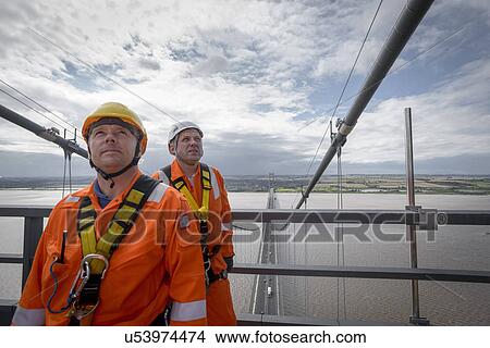 Picture - Portrait of bridge workers on top of suspension bridge. The Humber Bridge, UK was built in 1981 and at the time was the world's largest single-span suspension bridge. Fotosearch