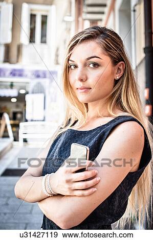Stock Photo - Portrait of confident young woman on city street. Fotosearch
