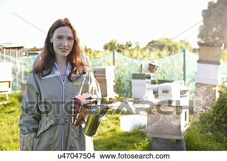 Picture - Portrait of female beekeeper on city allotment. Fotosearch