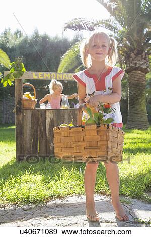 Portrait of girl carrying basket of lemons in front of lemonade stand View Large Photo Image Stock Photo - Portrait of girl carrying basket of lemons in front of lemonade stand. Fotosearch