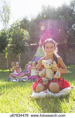 Portrait of girl holding teddy bear in front of teepee View Large Photo Image Stock Photograph - Portrait of girl holding teddy bear in front of teepee. Fotosearch