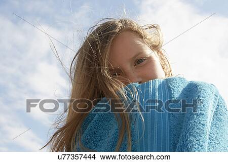Picture - Portrait of girl wrapped in towel at breezy coast. Fotosearch