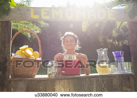 Portrait of proud girl on lemonade stand holding up one dollar bill View Large Photo Image Stock Image - Portrait of proud girl on lemonade stand holding up one dollar bill. Fotosearch