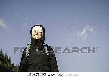 Portrait of smiling young woman in hooded anorak, Hundsarschjoch, Vils, Bavaria, Germany View Large Photo Image Stock Image - Portrait of smiling young woman in hooded anorak, Hundsarschjoch, Vils, Bavaria, Germany. Fotosearch