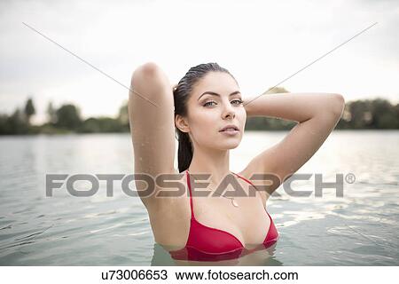 Stock Image - Portrait of sultry young woman in lake. Fotosearch