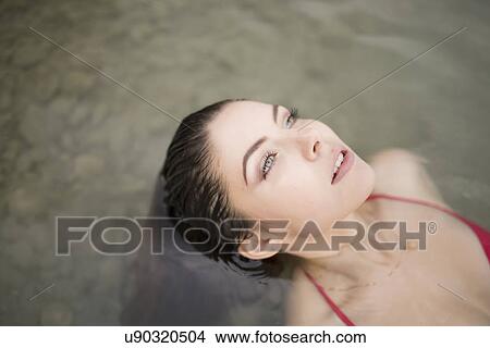 Portrait of sultry young woman lying back in lake View Large Photo Image Picture - Portrait of sultry young woman lying back in lake. Fotosearch