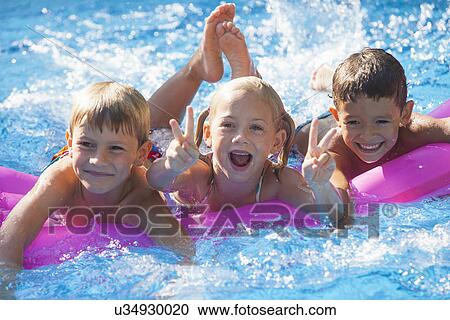 Portrait of three children playing on inflatable mattress in garden swimming pool View Large Photo Image Stock Image - Portrait of three children playing on inflatable mattress in garden swimming pool. Fotosearch