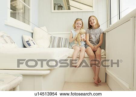 Portrait of two sisters sitting in holiday apartment porch View Large Photo Image Picture - Portrait of two sisters sitting in holiday apartment porch. Fotosearch