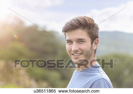 Portrait of young man smiling under bright sunlight View Large Photo Image Stock Photography - Portrait of young man smiling under bright sunlight. Fotosearch