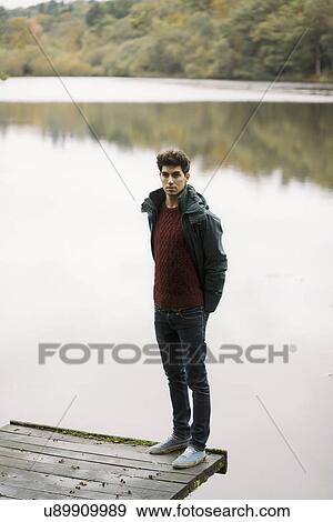 Portrait of young man standing on corner edge of river pier View Large Photo Image Stock Photo - Portrait of young man standing on corner edge of river pier. Fotosearch