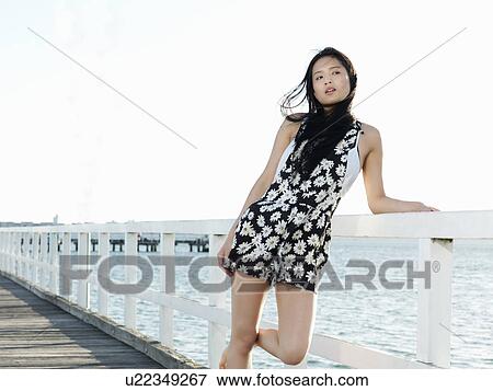 Portrait of young woman leaning against pier railings, Port Melbourne, Melbourne, Victoria, Australia View Large Photo Image Stock Photo - Portrait of young woman leaning against pier railings, Port Melbourne, Melbourne, Victoria, Australia. Fotosearch