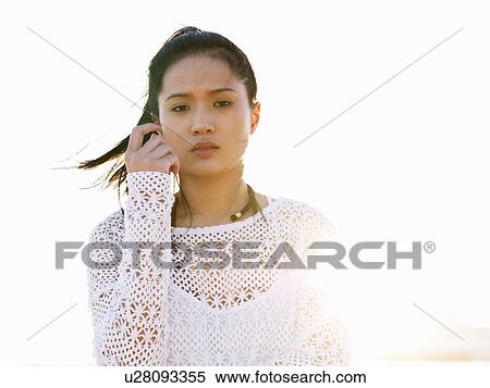 Stock Photography - Portrait of young woman on beach in sunlight, Port Melbourne, Melbourne, Victoria, Australia. Fotosearch