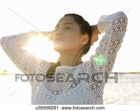 Portrait of young woman on beach with eyes closed and hands on head, Port Melbourne, Melbourne, Victoria, Australia View Large Photo Image Stock Image - Portrait of young woman on beach with eyes closed and hands on head, Port Melbourne, Melbourne, Victoria, Australia. Fotosearch