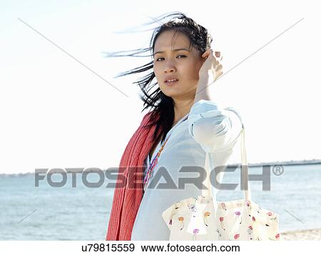 Stock Photo - Portrait of young woman on beach with beach towel, Port Melbourne, Melbourne, Victoria, Australia. Fotosearch