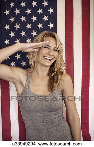Picture - Portrait of young woman saluting in front of american flag. Fotosearch