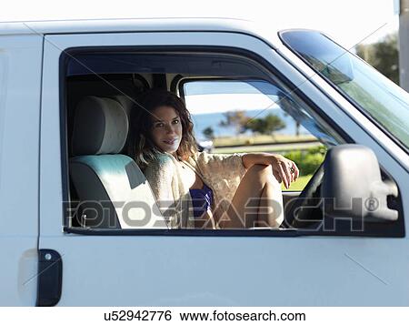 Stock Photograph - Portrait of young woman sitting in van at beach, Williamstown, Melbourne, Australia. Fotosearch