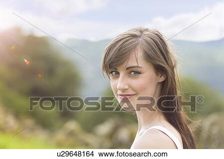 Picture - Portrait of young woman smiling in sunny countryside, close up. Fotosearch