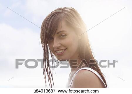 Portrait of young woman smiling under bright sunlight View Large Photo Image Stock Photo - Portrait of young woman smiling under bright sunlight. Fotosearch