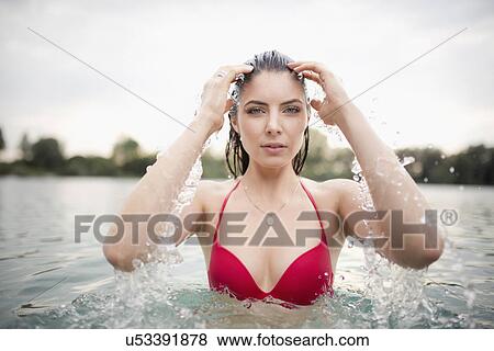Portrait of young woman splashing water in hair in lake View Large Photo Image Stock Photo - Portrait of young woman splashing water in hair in lake. Fotosearch