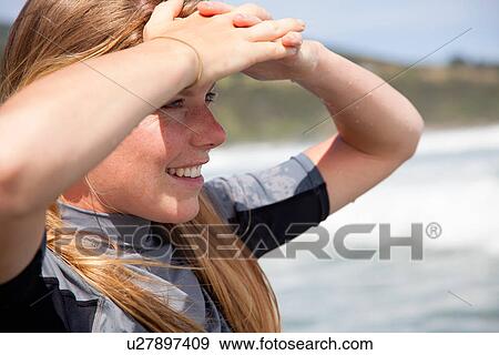 Portrait of young woman wearing wetsuit, looking out to sea View Large Photo Image Stock Photo - Portrait of young woman wearing wetsuit, looking out to sea. Fotosearch