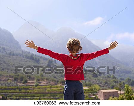 Rear view of boy looking at mountains with arms outstretched, Majorca, Spain View Large Photo Image Stock Image - Rear view of boy looking at mountains with arms outstretched, Majorca, Spain. Fotosearch