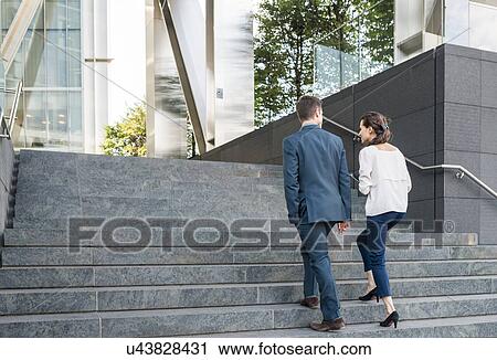 Rear view of young businessman and woman walking up stairway, London, UK View Large Photo Image Stock Image - Rear view of young businessman and woman walking up stairway, London, UK. Fotosearch