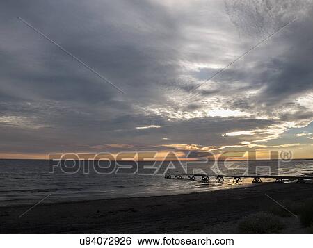 Stock Photograph - Sea and silhouetted pier at sunrise, Oland, Sweden. Fotosearch