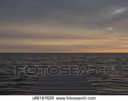 Stock Photo - Seascape with pier at sunrise. Fotosearch