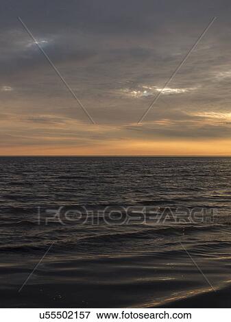 Stock Photo - Seascape with sunrise over horizon. Fotosearch