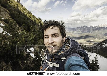 Self portrait of young man in mountains, Hundsarschjoch, Vils, Bavaria, Germany View Large Photo Image Stock Photo - Self portrait of young man in mountains, Hundsarschjoch, Vils, Bavaria, Germany. Fotosearch
