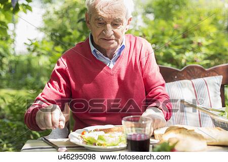 Senior man having lunch outdoors View Large Photo Image Stock Photo - Senior man having lunch outdoors. Fotosearch