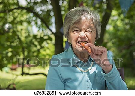 Senior woman biting sausage View Large Photo Image Stock Image - Senior woman biting sausage. Fotosearch