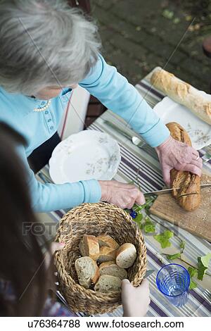 Senior woman cutting bread, high angle View Large Photo Image Stock Photo - Senior woman cutting bread, high angle. Fotosearch
