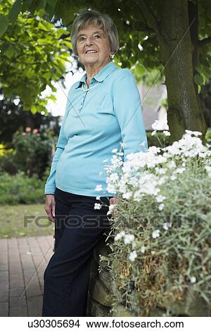 Senior woman in garden View Large Photo Image Picture - Senior woman in garden. Fotosearch