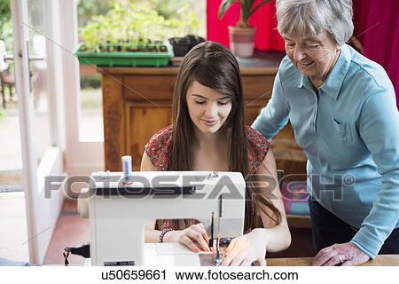 Senior woman watching granddaughter use sewing machine View Large Photo Image Stock Image - Senior woman watching granddaughter use sewing machine. Fotosearch